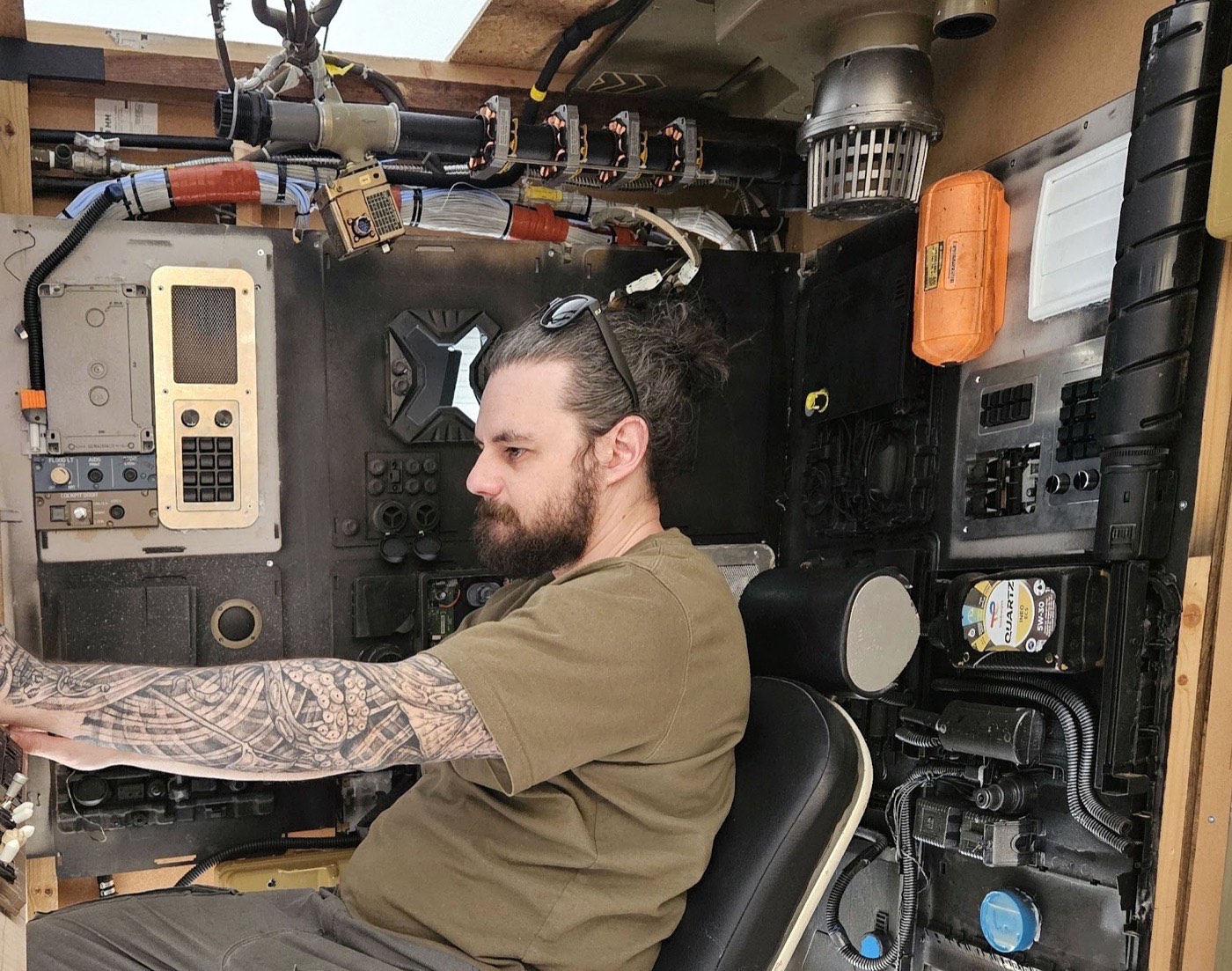 Cockpit de vaisseau spatial construit à la main, avec un pilote aux commandes.